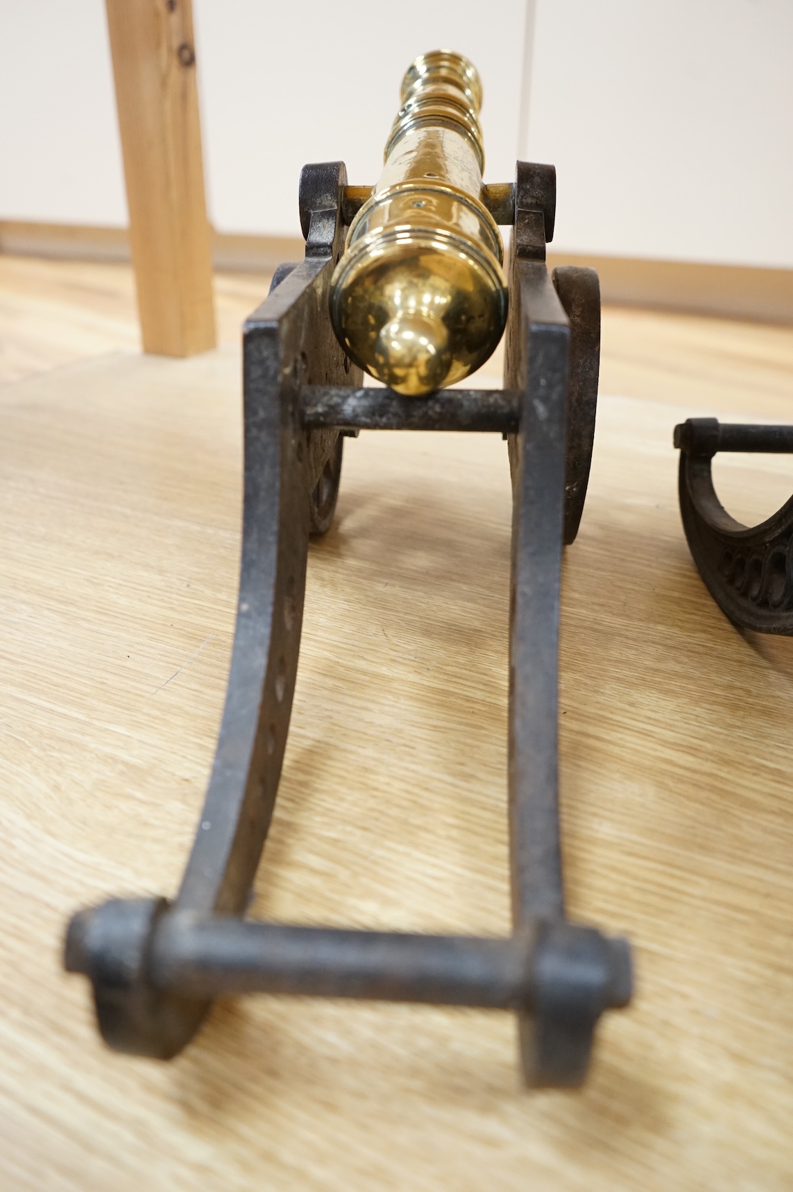 A decorative pair of brass model cannons, with turned barrels, 29cm overall, on cast iron pierced carriages with pierced wheels, overall length 46cm